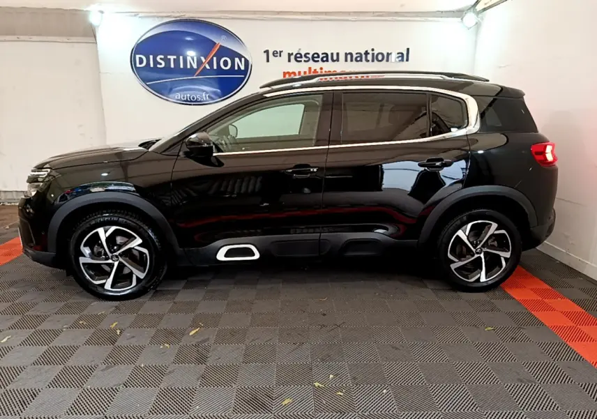 Profil droit d'un SUV Citroën C5 Aircross noir avec jantes alliage et détails chromés sous un éclairage intérieur.