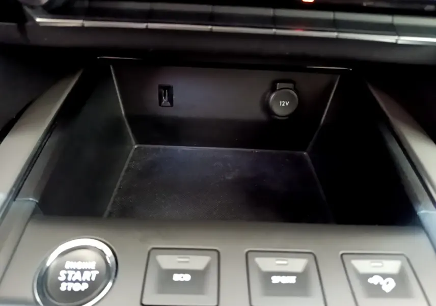 Gros plan sur la console centrale noire du Citroën C5 Aircross avec bouton démarrage et prises 12V visibles