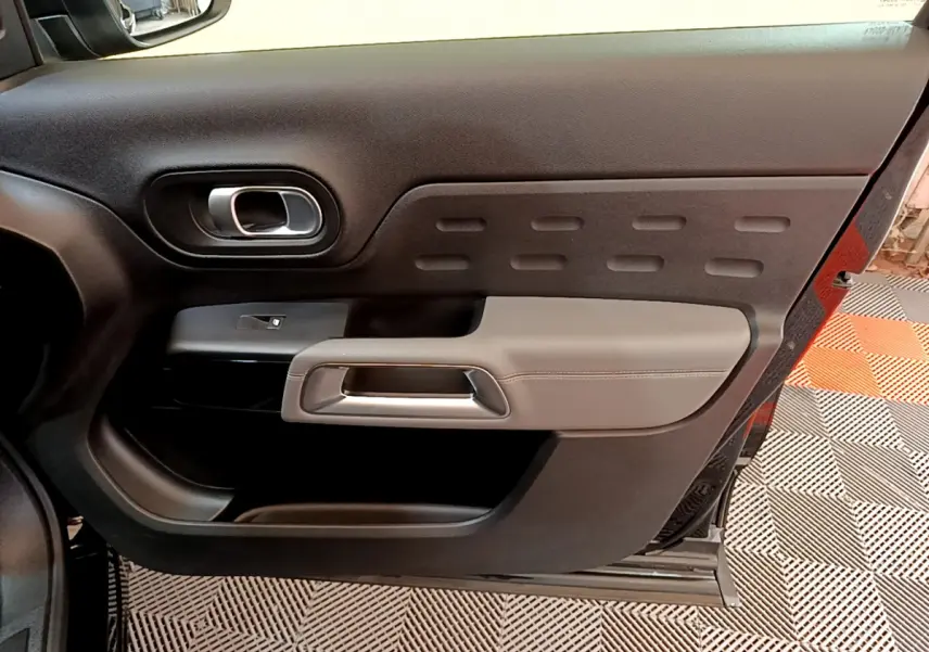 Vue intérieure du panneau de porte côté droit noir et gris du Citroën C5 Aircross 2020 avec poignée argentée.
