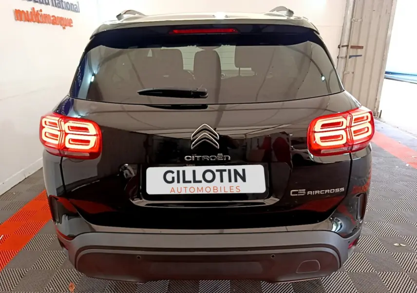 Vue arrière du Citroën C5 Aircross noir avec feux arrière LED allumés dans un garage intérieur.