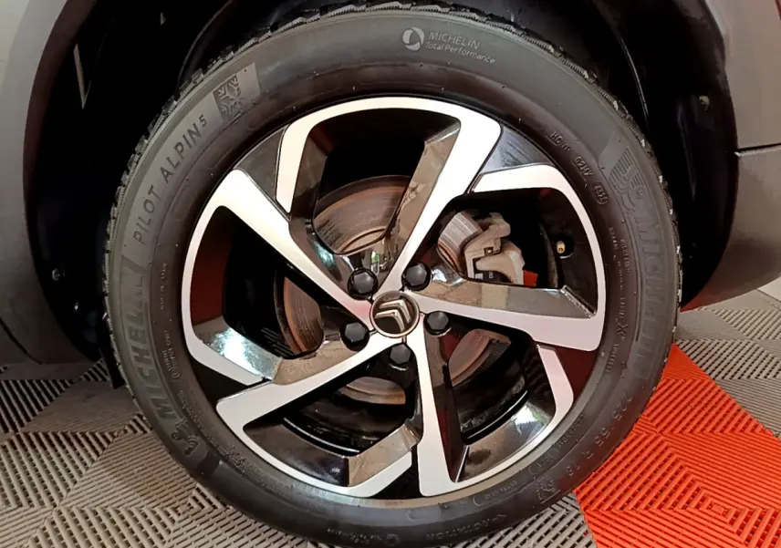 Gros plan sur la jante alliage bicolore et pneu Michelin d'un Citroën C5 Aircross noir, côté avant droit.