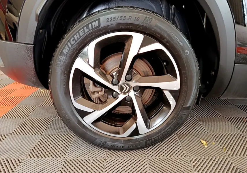 Gros plan sur la roue avant droite du Citroën C5 Aircross noir, avec jante alliage bicolore et pneu Michelin.