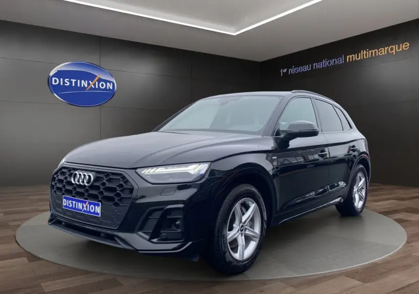 Audi Q5 Business Edition S-Line noir, vue 3/4 avant droite, avec calandre hexagonale et phares LED matrix allumés.