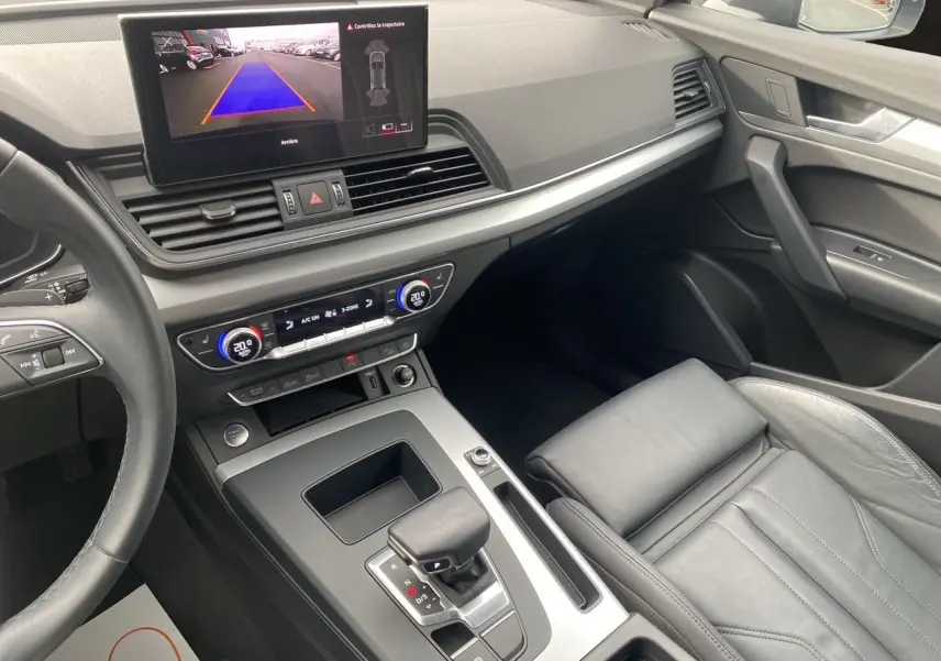 Vue intérieure côté passager de l'Audi Q5 noire 2022, avec écran multimédia affichant la caméra de recul.