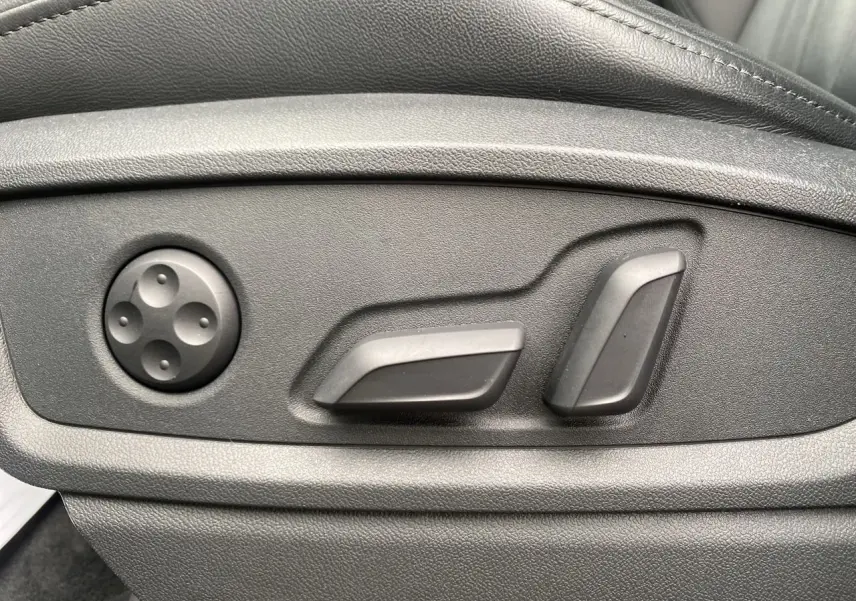 Gros plan sur les commandes électriques de réglage du siège avant côté gauche en cuir noir de l'Audi Q5 Business Edition 2022.