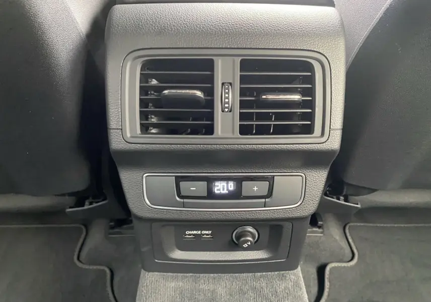 Vue rapprochée de la console arrière noire de l'Audi Q5 2022 avec sorties d'air, réglage climatisation et ports USB.