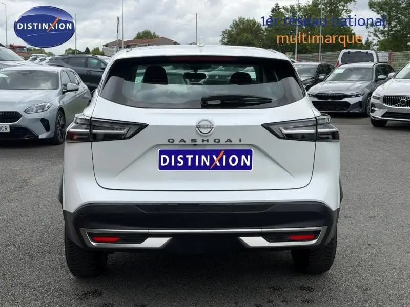 Vue arrière d'un Nissan Qashqai blanc nacré 2025 avec feux arrière LED et logo distinctif au centre.