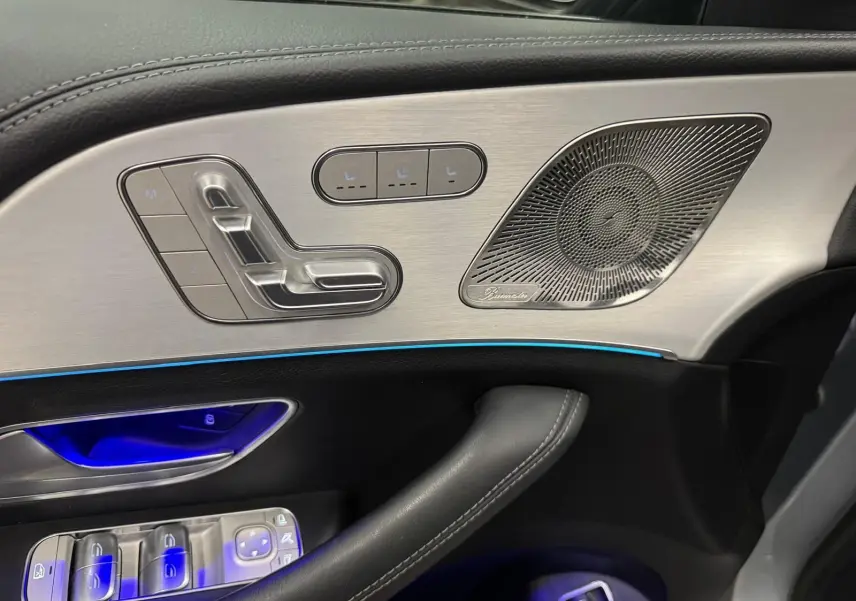 Détail de la porte côté conducteur du Mercedes GLE 400 E Hybrid AMG Line 2023, avec commandes sièges et haut-parleur Burmester.