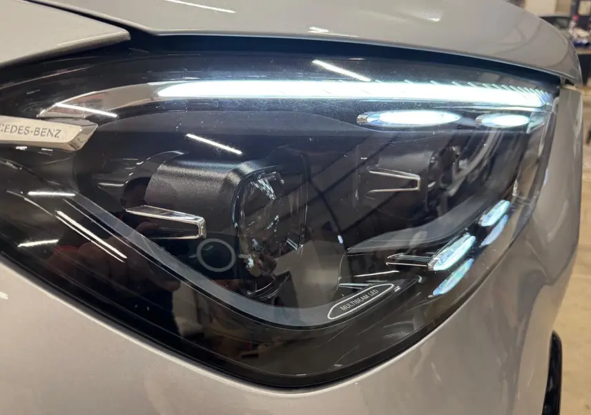 Gros plan sur le phare avant droit argent High-tech métallisé du Mercedes GLE 400 E HYBRID AMG LINE 2023 avec éclairage Multibeam LED.