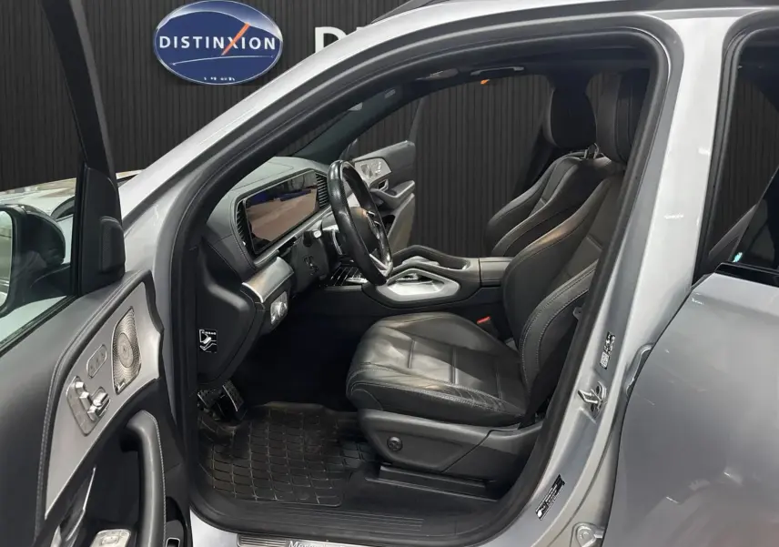 Intérieur côté conducteur d’un Mercedes GLE 400 E Hybrid AMG Line 2023 argent, sièges cuir noir et tableau de bord moderne.