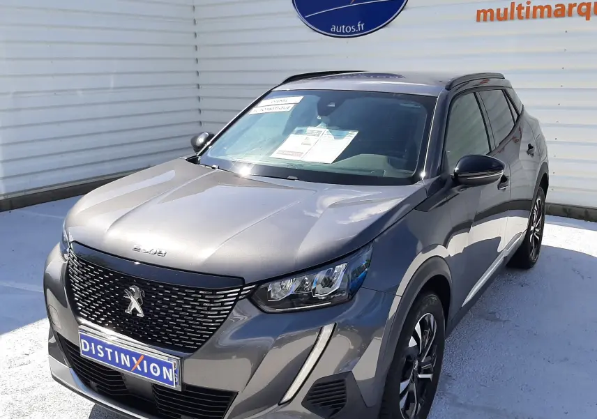 Peugeot 2008 gris platinium en 3/4 avant droit, avec calandre noire et feux LED distinctifs visibles.