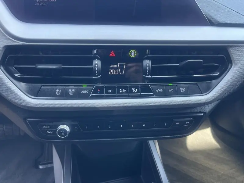 Tableau de bord central de BMW Série 1 116dA 2020, avec commandes climatisation et audio visibles en gros plan.