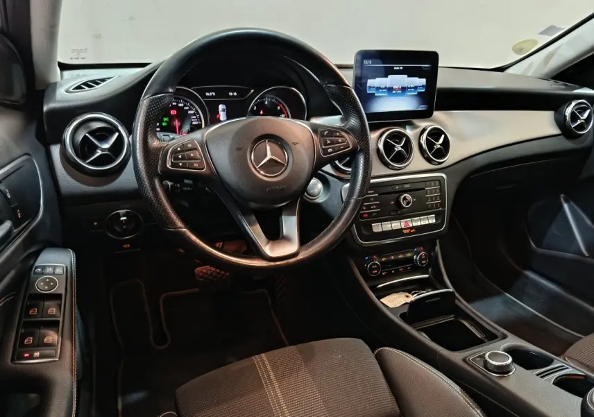 Intérieur noir de la Mercedes GLA 200 d 2018, vue de face sur le volant cuir et le tableau de bord avec écran central.