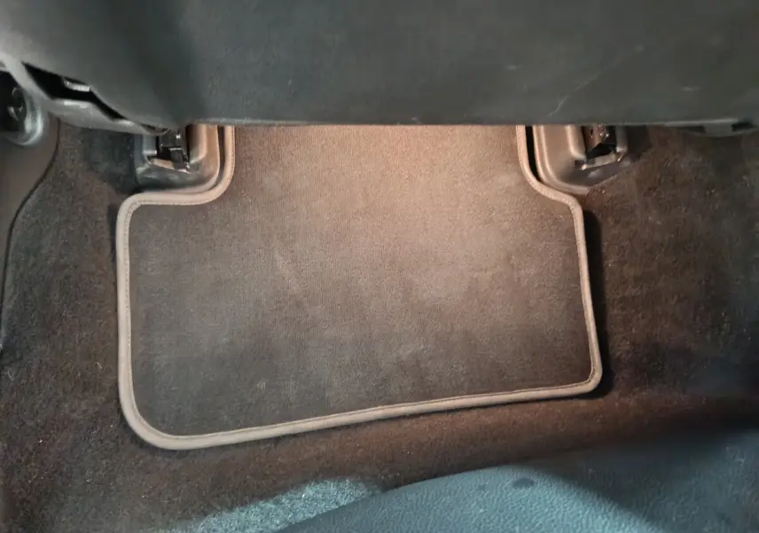 Tapis de sol noir côté passager arrière d'un Mercedes GLA 200 d Business Executive gris clair, vue intérieure basse.