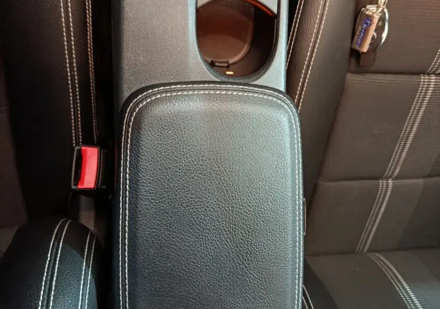 Vue plongeante sur la console centrale en cuir noir avec coutures blanches et siège tissu gris du Mercedes GLA 200 d 2018.