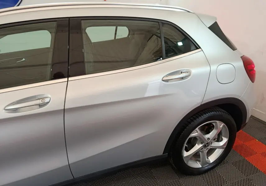Vue latérale côté droit du Mercedes GLA 200 d gris clair, mettant en valeur les poignées chromées et la jante alliage.