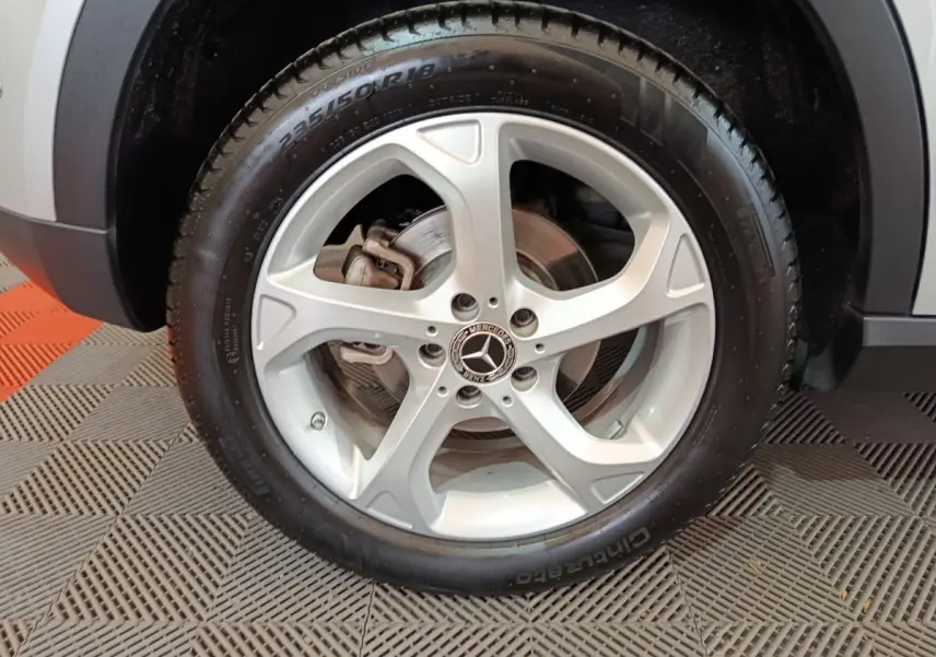 Gros plan sur la roue avant droite gris clair d'un Mercedes GLA 200 d avec jante alliage cinq branches et logo Mercedes central.