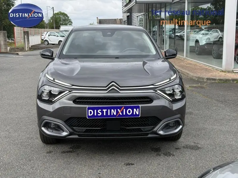 Vue frontale d'une Citroën C4 X 2024 gris Platinium avec calandre distinctive et feux LED fins.