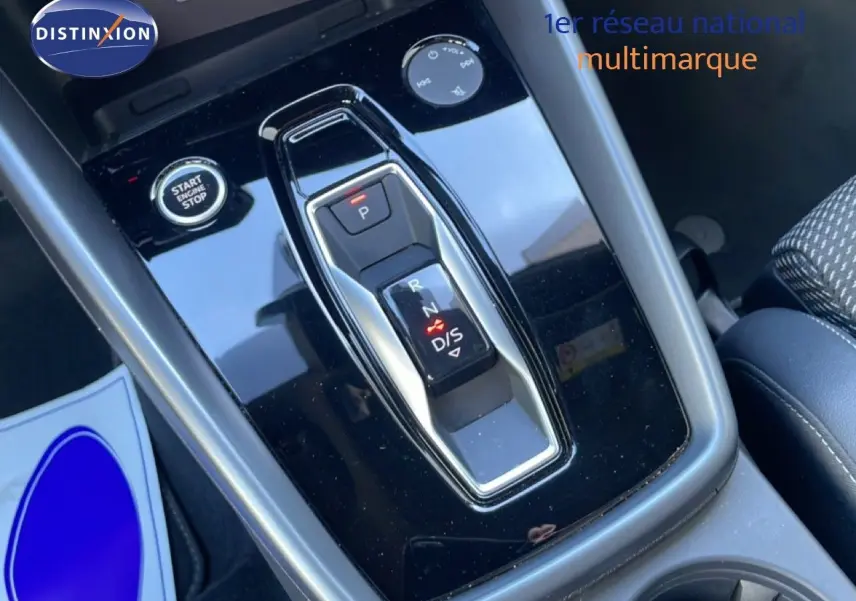 Gros plan sur la console centrale noire brillante de l'Audi A3 Sportback 40 TFSIe, avec levier de vitesse automatique et bouton start/stop.