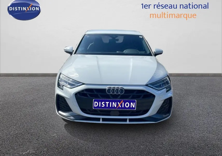 Vue avant d'une Audi A3 Sportback blanche Ibis 2025 avec calandre noire et phares LED distinctifs.