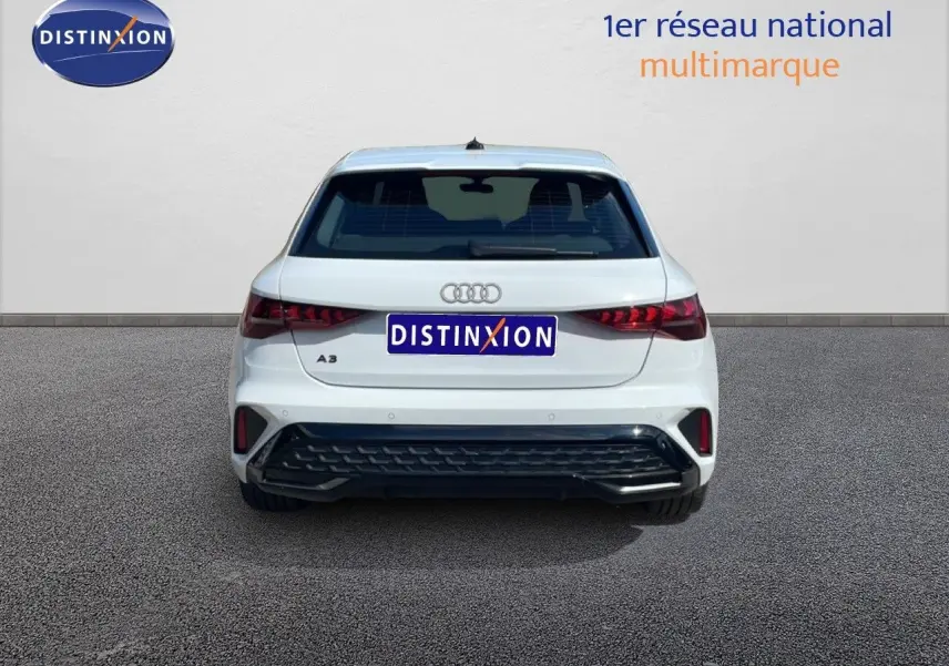 Vue arrière d'une Audi A3 Sportback blanche Ibis 2025 avec logo Audi et feux arrière LED distinctifs.