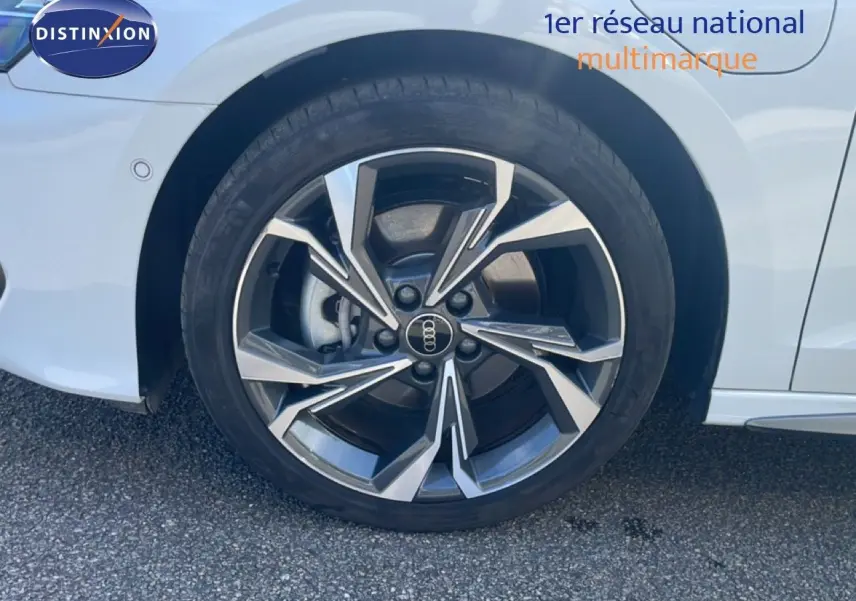 Gros plan sur la roue avant gauche d'une Audi A3 Sportback blanche Ibis avec jante alliage S-Line distinctive.