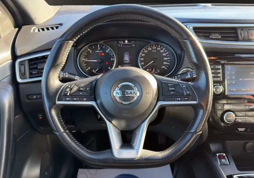 Vue intérieure centrée sur le volant cuir noir du Nissan Qashqai 1.6 DCI 130 Tekna+ avec tableau de bord et écran tactile.
