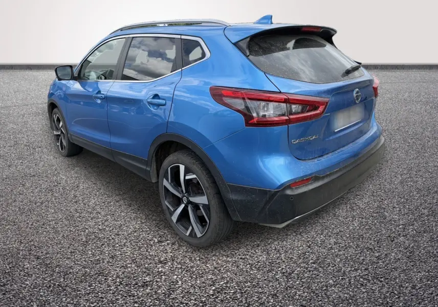 Nissan Qashqai bleu en 3/4 arrière droit, avec jantes alliage noires et toit avec spoiler noir.