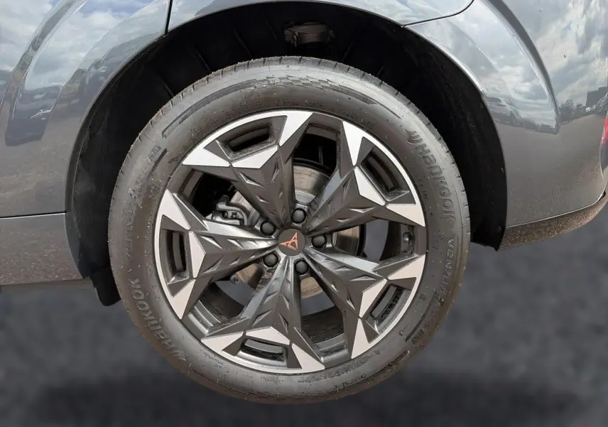 Gros plan sur la jante alu 19 pouces gris foncé avec logo CUPRA, sur roue arrière droite d’une CUPRA Terramar gris timanfaya.