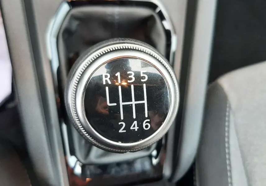 Gros plan sur le levier de vitesses manuel de la Renault Clio V gris schiste, avec marquage des six rapports et marche arrière.