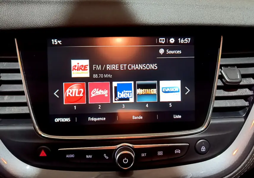 Écran tactile central allumé affichant les stations radio dans l'habitacle d'une Opel Grandland X noire.