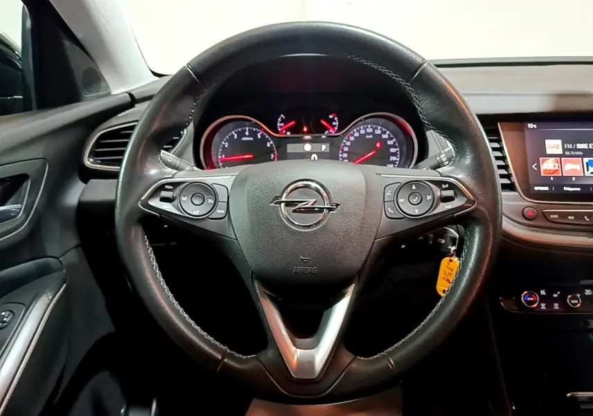 Intérieur noir de l'Opel Grandland X 2021, vue centrée sur le volant cuir et le tableau de bord avec écran tactile.