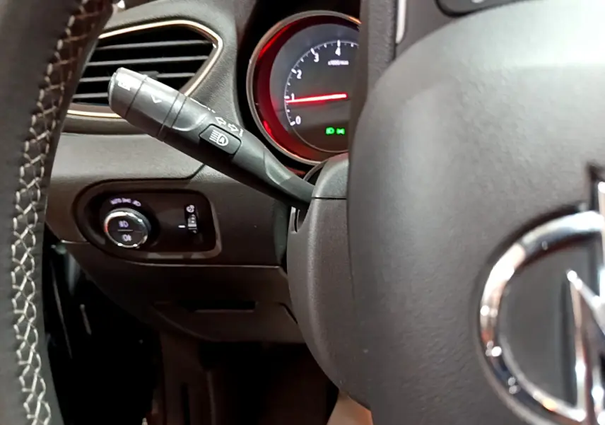 Gros plan sur le volant noir et la manette de clignotant gauche de l'Opel Grandland X 1.5 Diesel 130 Elegance Business Auto de 2021.