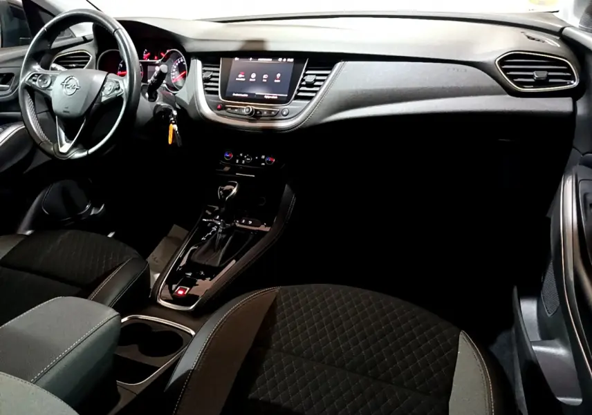 Intérieur noir de l’Opel Grandland X 2021, vue du tableau de bord et console centrale avec écran tactile et volant multifonctions.