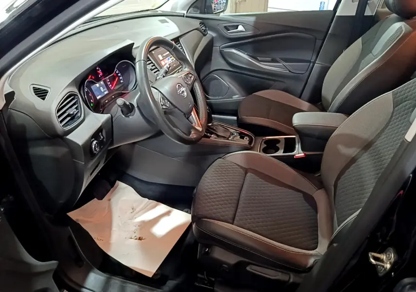 Intérieur avant droit de l’Opel Grandland X 2021 avec sièges tissu noir et tableau de bord moderne équipé d’un écran tactile.