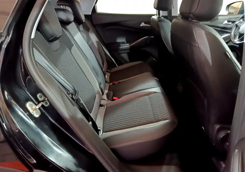 Vue intérieure côté gauche sur la banquette arrière en tissu gris et noir du Opel Grandland X noir 2021.