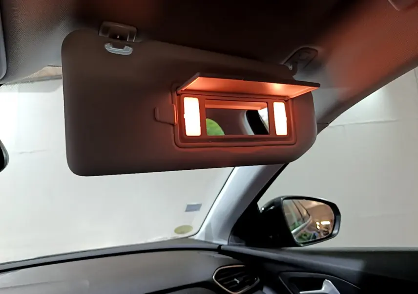 Miroir de courtoisie éclairé sur pare-soleil côté conducteur dans l'habitacle noir d'un Opel Grandland X 2021.