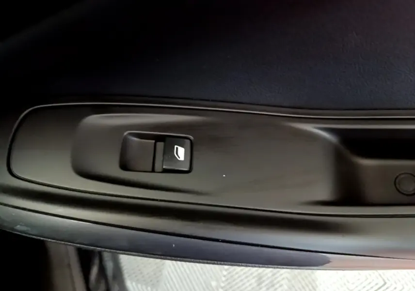 Bouton de commande de lève-vitre noir sur panneau de porte intérieur d'Opel Grandland X noir.