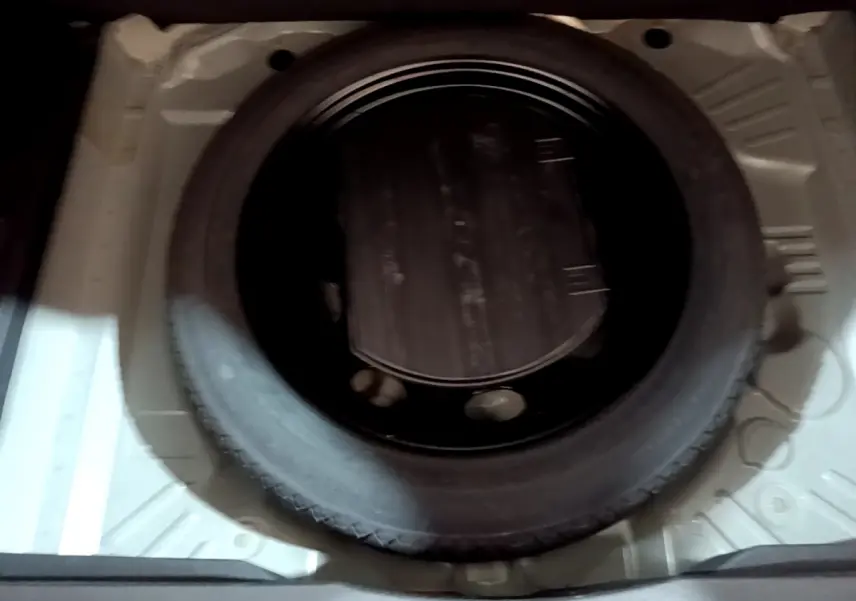 Roue de secours noire vue de dessus dans le compartiment de coffre d'un Opel Grandland X noir 2021.