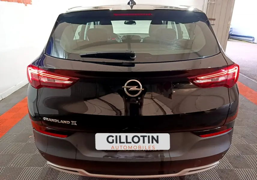 Vue arrière d'un Opel Grandland X noir avec feux LED allumés et logo Opel bien visible sur le coffre.
