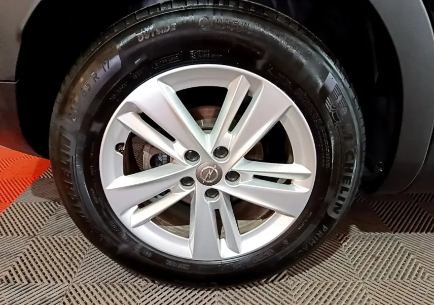 Gros plan sur la roue avant droite de l'Opel Grandland X noir avec jante alliage et pneu Michelin.