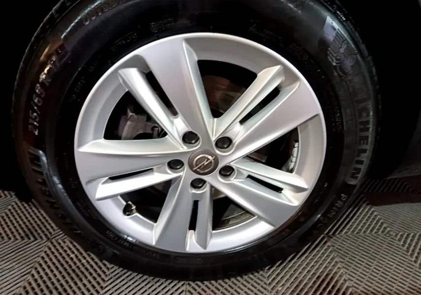 Gros plan sur la jante argentée avec logo Opel d'un Grandland X noir, mettant en valeur le pneu Michelin.
