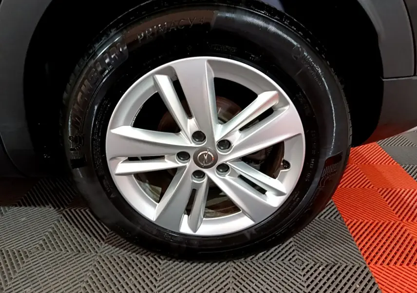 Gros plan sur la jante argentée et le pneu Michelin d'un Opel Grandland X noir, vue côté roue arrière.
