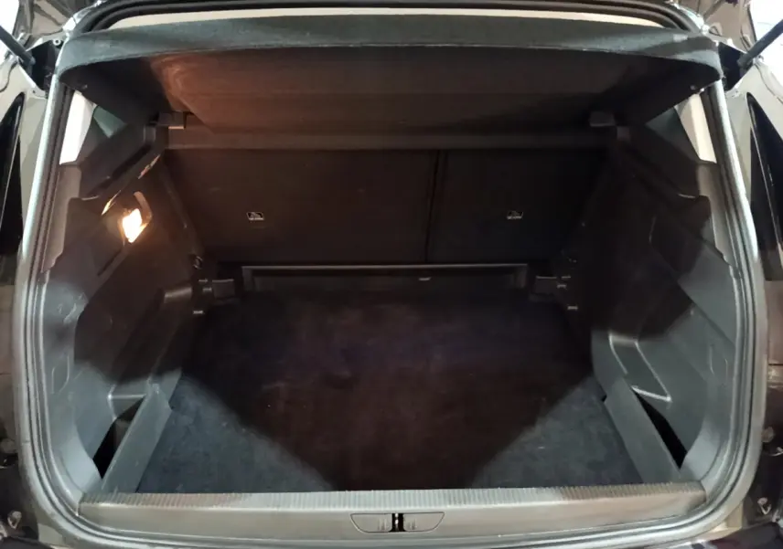 Coffre ouvert noir de l'Opel Grandland X 1.5 Diesel 130 Elegance Business vu de l'arrière intérieur.