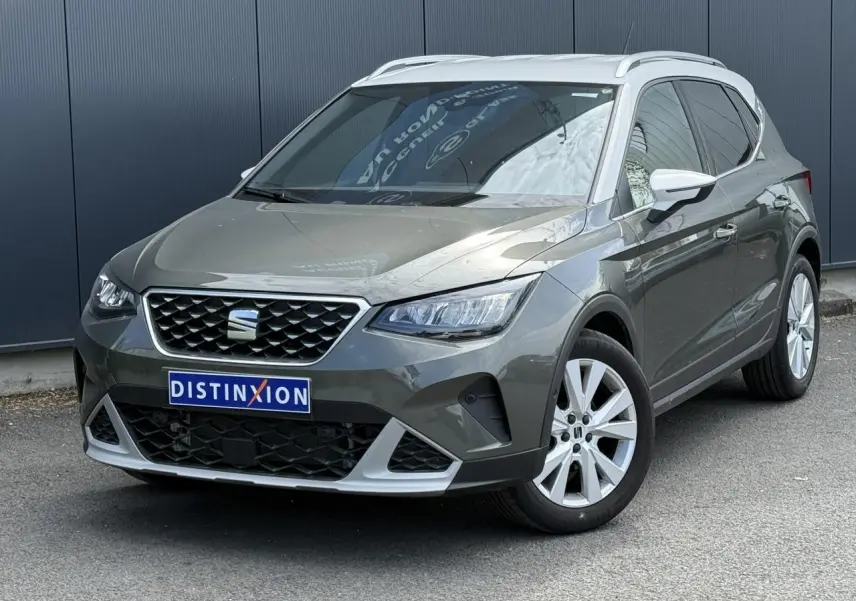 SEAT Arona Gris Cliff vue 3/4 avant droit, calandre chromée et jantes alliage 17 pouces blanches.