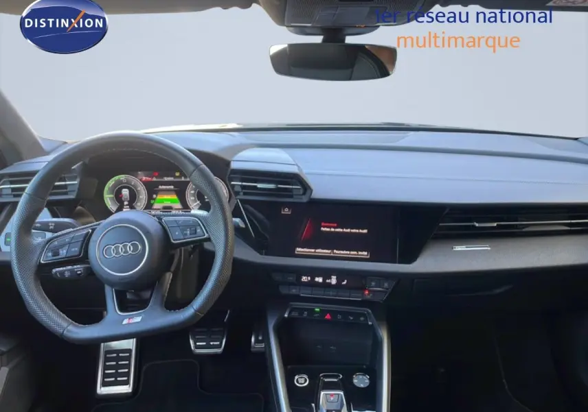 Vue intérieure avant de l'Audi A3 Sportback 2025 noire, mettant en valeur le volant multifonction et le tableau de bord digital.