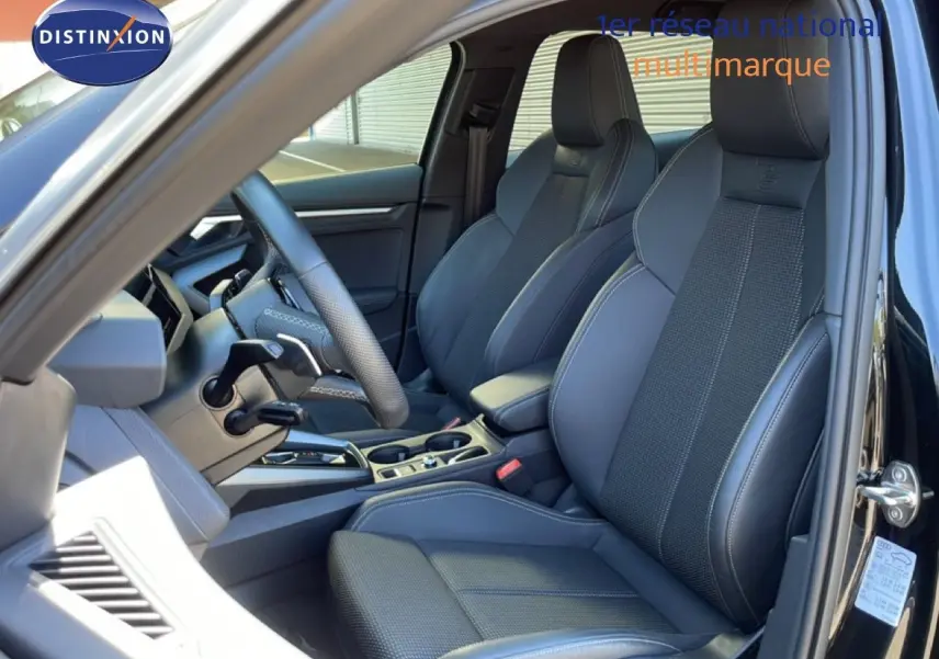 Vue intérieure côté conducteur de l'Audi A3 Sportback 40 TFSIe S-Line 2025 avec sièges en cuir noir et volant multifonction.