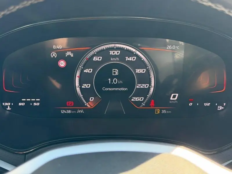 Vue rapprochée du tableau de bord numérique du SEAT Arona 2025 affichant la consommation et la vitesse à 0 km/h.
