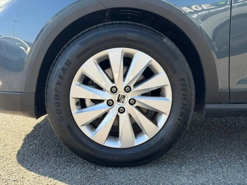 Gros plan sur la roue avant droite d’un SEAT Arona gris Magnétique Métal avec jante alu et pneu Goodyear.