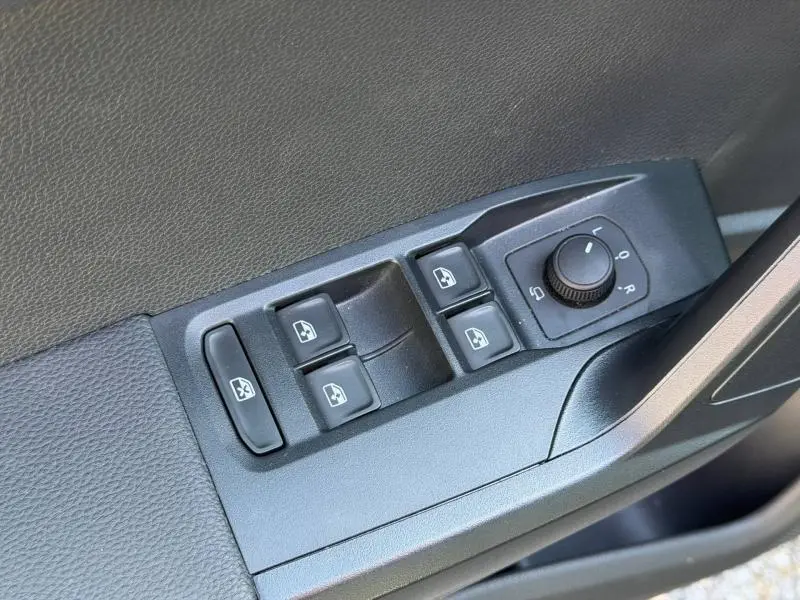 Gros plan sur les commandes des vitres et des rétroviseurs côté conducteur du SEAT Arona gris Magnétique Métal.